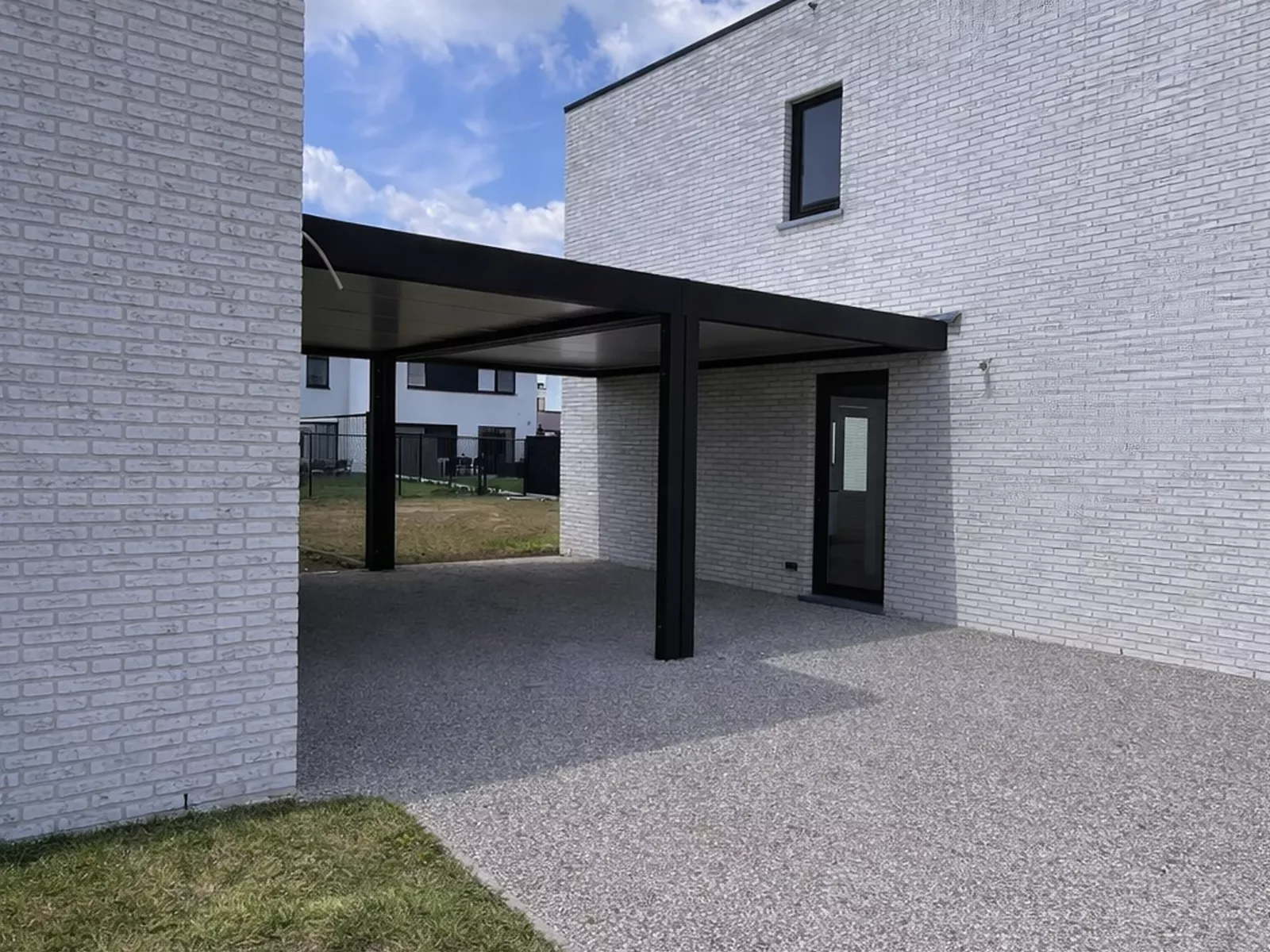 gekoppelde strakke carports tussen twee woningen Astene